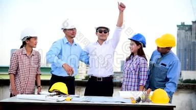 建筑工程师团队合作安全套装信任团队手持白色黄色安全安全帽安全设备